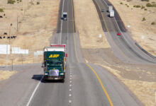 A green ABF Freight tractor pulling a trailer on a highway