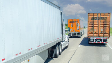 A Schneider dry van trailer being pulled next to a Schneider intermodal container on a highway