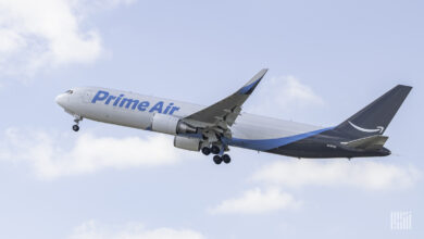 A blue-tailed Prime Air cargo jet rises into the sky.