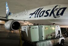 An Alaska Airlines jet takes on cargo at night.