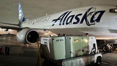 An Alaska Airlines jet takes on cargo at night.