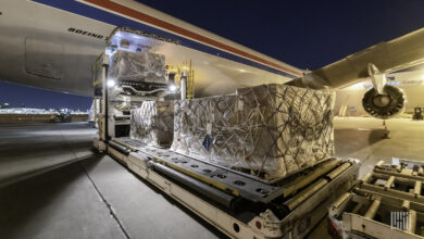Night loading of large pallets on a cargo jet using moving equipment.