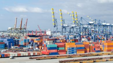 Image shows container cranes, containers and doublestack railroad cars at the Port of Los Angeles.