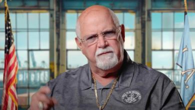 Image shows older bald man with a white goatee.