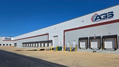 An AGS warehouse with multiple truck doors on a clear day.