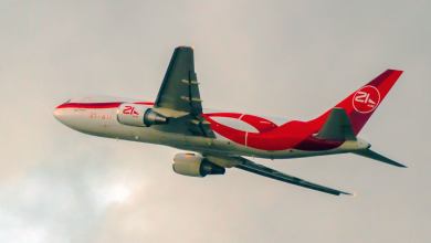 A red-and-white jetliner takes off into the clouds.