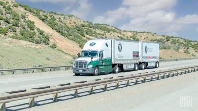 An Old Dominion tractor pulling two pup trailers on a highway