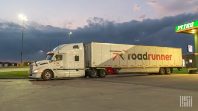 A white Roadrunner sleeper cab pulling a 53-foot Roadrunner trailer at a Petro station