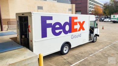 Close up photo of a FedEx Ground delivery van pulled up to a loading dock.
