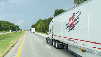 A sideview of a Heartland trailer moving a highway