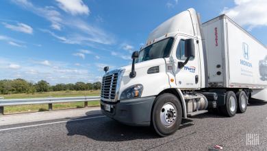 A white TForce Freight daycab pulling a Honda-labeled trailer