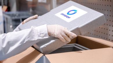 A technician with surgical gloves holds a CryoPDP insulated package.