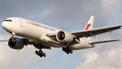 A white China Cargo Airline jet comes in for a landing with wheels down.