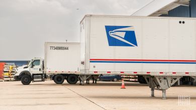 Side viiew of U.S. Postal Service trailers at a truck loading zone.