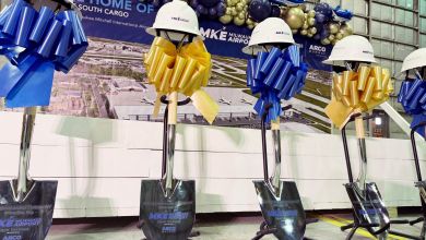 Helmets resting on shovel handles at a groundbreaking ceremony.
