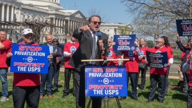 Speakers and protesters in front of the U.S. Capitol building with signs opposing corporate takeover of the U.S. Postal Service.