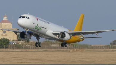 A SmartLynx Cargo plane, white and gold rear section takes off.