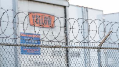 Yellow trailers parked along a fence at a terminal