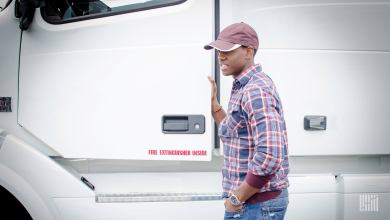 a driver climbing into a white tractor cab