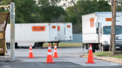 Orange cones blocking entrance at a Yellow terminal with trucks and trailers in the background