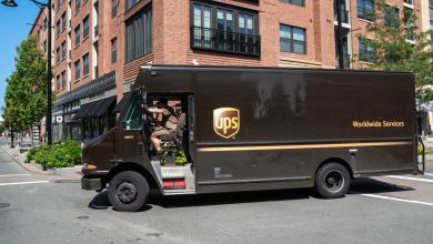 A brown UPS delivery van on a Boston city street.