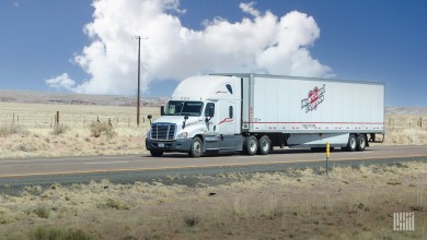 a white sleeper cab pulling a Heartland Express dry van trailer