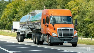 An orange sleeper cab pulling a Heniff tank trailer