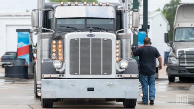 Truck driver standing outside his truck.