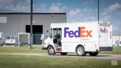 A FedEx Ground delivery van drives into a parcel terminal.