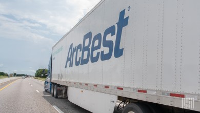 A side view of an ArcBest trailer on a highway