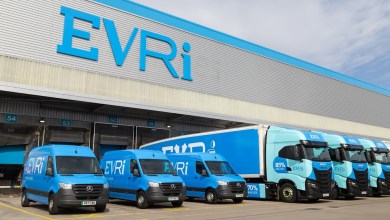Light blue Evri delivery vans and heavy trucks at an Evri warehouse dock.