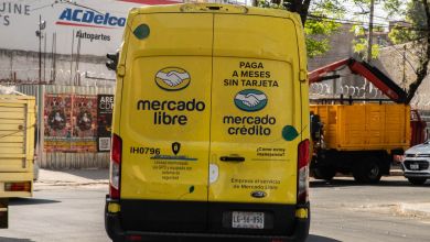 Rear view of a yellow Mercado Libre delivery van on a city street.