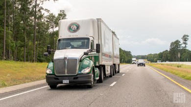 An Old Dominion tractor pulling two Old Dominion trailers on a highway