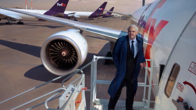 FedEx founder Fred Smith is pictured on a stairway by the door of a FedEx cargo jet.