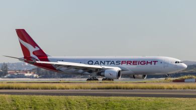 A red-tailed Qantas Freight cargo jet on the runway.