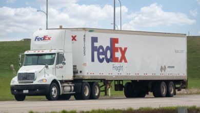 A FedEx Freight tractor trailer on the road. Blue and red lettering.
