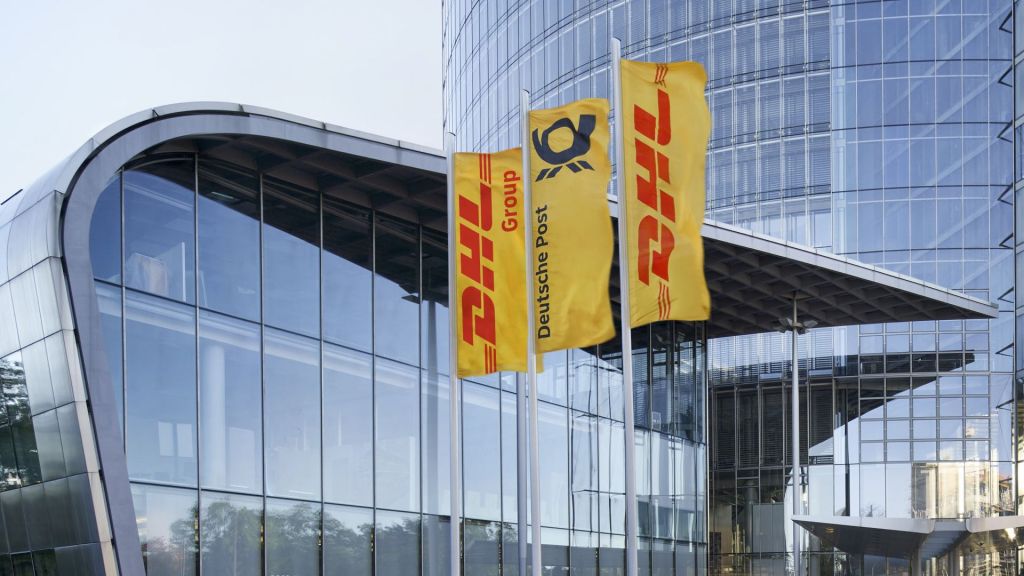 Gold-and-red DHL flags flying in front of glass headquarters building.