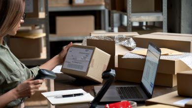 A woman weighs a package and affixes a label before shipping it.