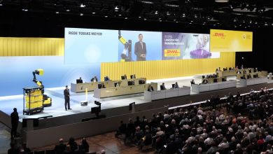 View of stage at a DHL annual meeting, with DHL yellow signage.