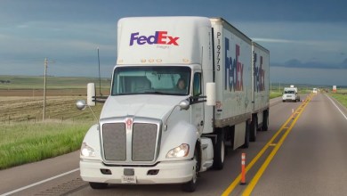 A white FedEx Freight tractor pulling two FedEx pup trailers