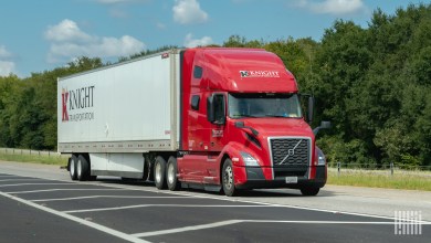 A red Knight sleeper cab pulling a white Knight trailer on a highway