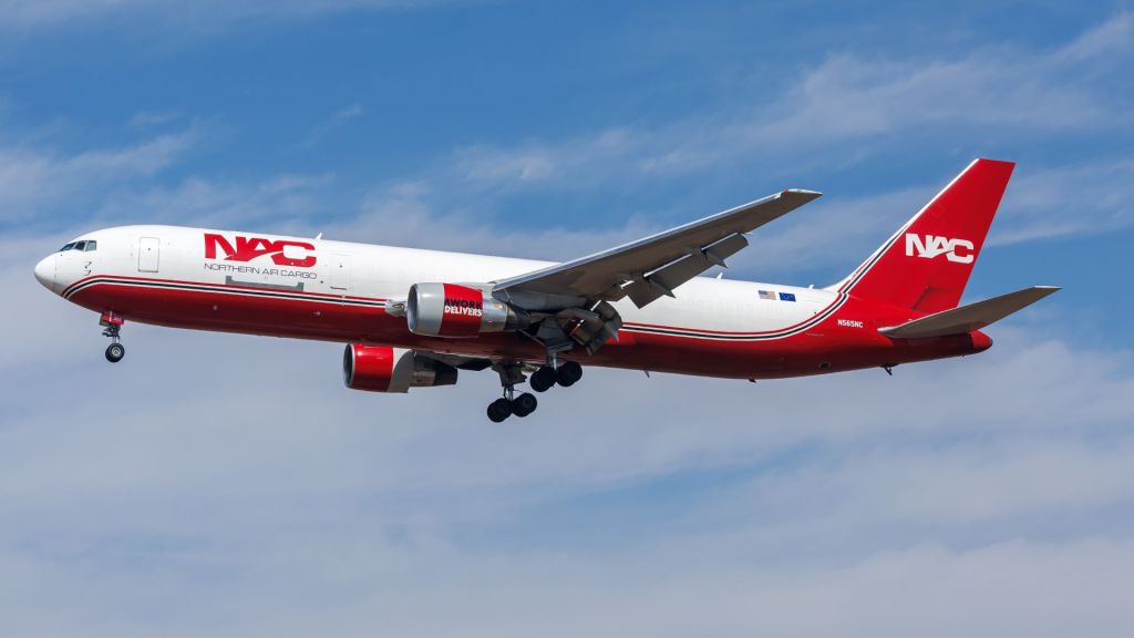 Red-and-white Northern Air Cargo Boeing 767 aircraft approaches airport for landing.