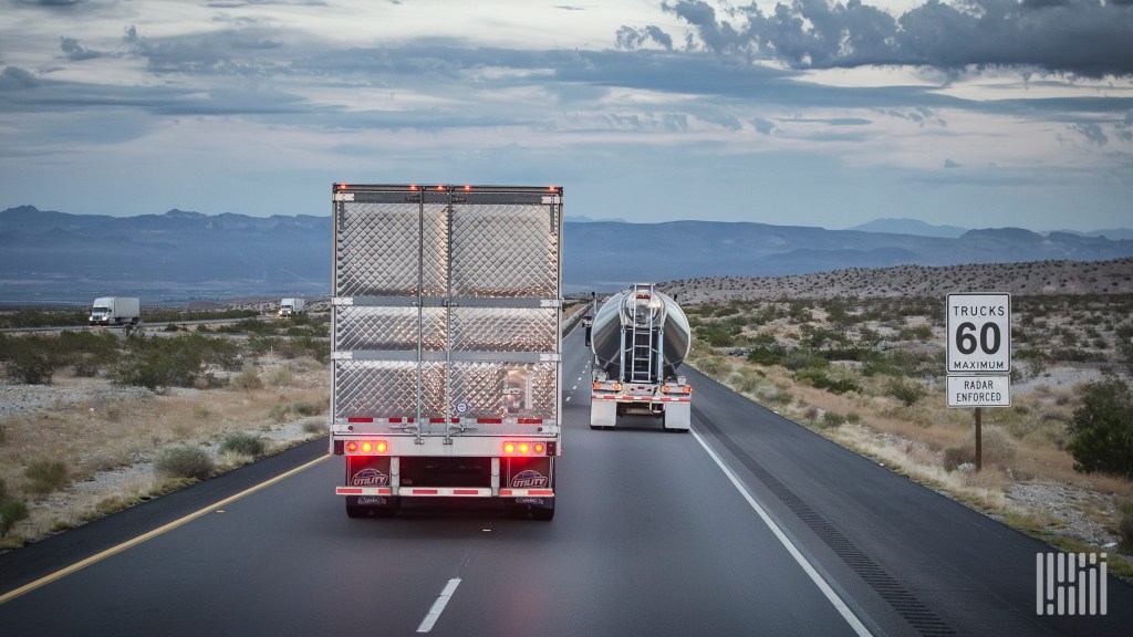 trucks on highway with speed limit 60 sign