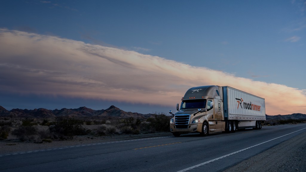 A gold Roadrunner sleeper cab pulling a white Roadrunner trailer