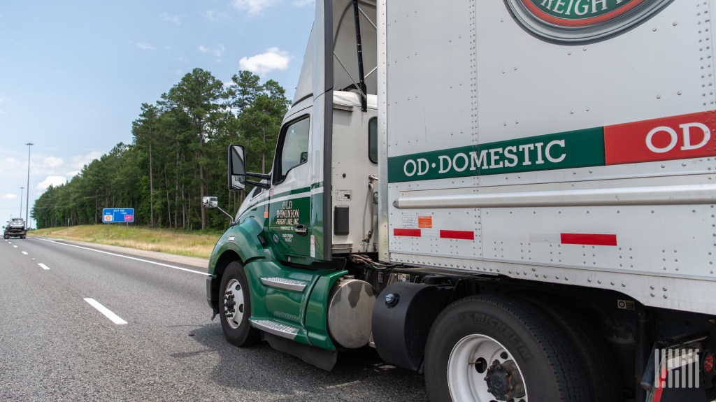 A closeup of an Old Dominion tractor pulling a trailer on a highway