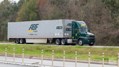 A green ABF Freight daycab pulling an ABF dryvan trailer on a highway