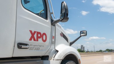 A closeup of a white XPO tractor on a highway