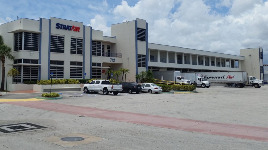 Front view of the StratAir warehouse with a Forward Air truck at the dock.