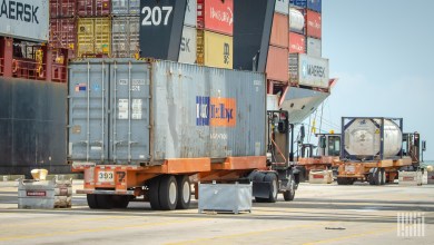 a truck pulling a chassis with a container at a port