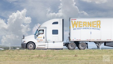 Sideview of a Werner sleeper cab with a driver and a Werner trailer